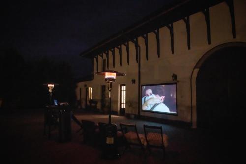a large screen tv on the side of a building at night at Domeniul Drăgași in Călina