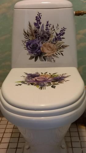 a toilet with a flower arrangement on the lid at Ventspils Juras in Ventspils