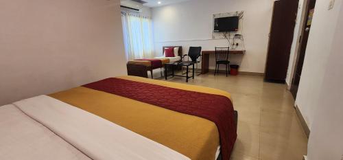 ein Hotelzimmer mit einem Bett und einem Wohnzimmer in der Unterkunft HOTEL SASHI GRANd in Vijayawāda