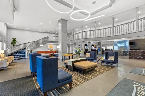 a lobby with blue chairs and a staircase at Radisson Hotel Salt Lake City Airport in Salt Lake City