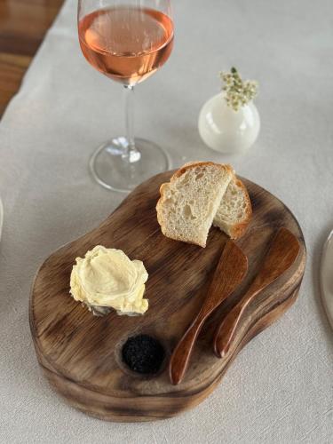 a wooden cutting board with bread and a glass of wine at Domeniul Drăgași in Călina