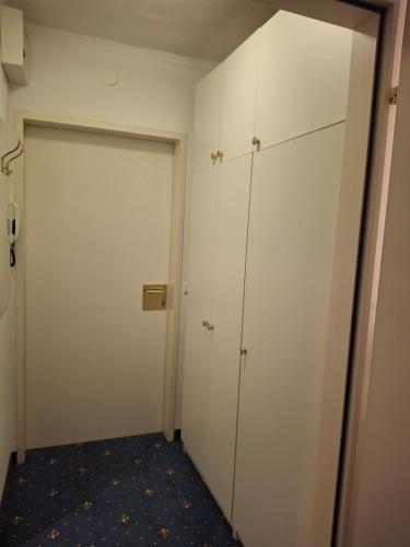 an empty room with white cabinets and a door at Golfplatz in Bad Ischl