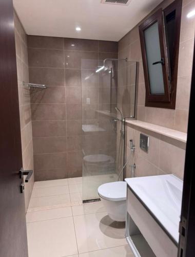 Un baño con ducha, inodoro y lavabo. en Hawana salalah, en Salalah