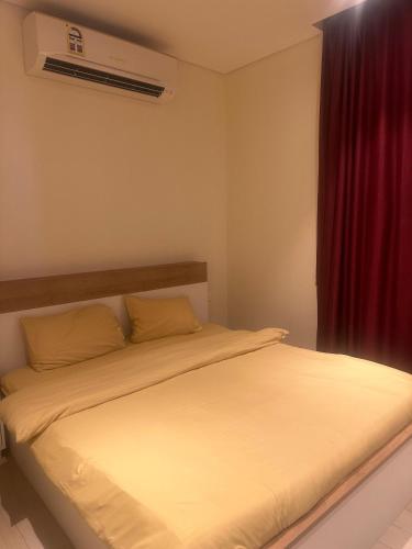 Un dormitorio con una cama con una cortina roja. en Hawana salalah, en Salalah