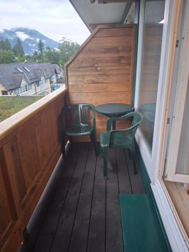 a porch with two chairs and a table and a window at Golfplatz in Bad Ischl