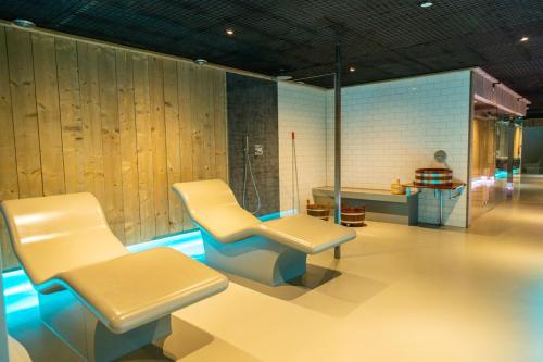 a room with two chairs and a table in it at Marina Strandbad Chalet Inselperle mit Zaun & AirCo Nr 84 in Olburgen