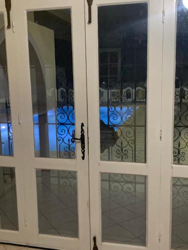 a pair of glass doors with a gate at Villa Sandrella Tazdaine in Temlale