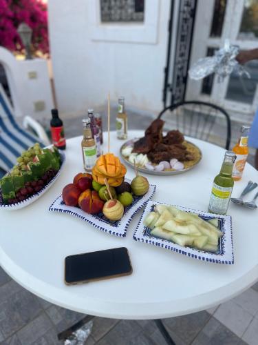 a white table with plates of food on it at Villa Sandrella Tazdaine in Temlale