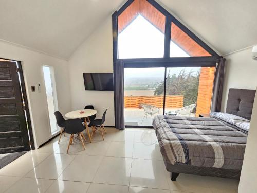 a bedroom with a bed and a table with chairs at Casa Pacari in Algarrobito