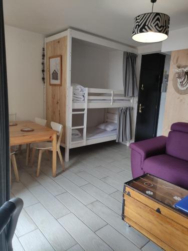 un salon avec un canapé violet et une table dans l'établissement Résidence Béro Bisto Studio 4 pers la Mongie Grand Tourmalet, à Bagnères-de-Bigorre