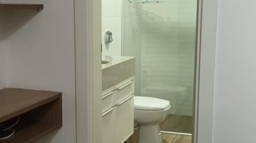 a bathroom with a toilet and a glass shower at Sossego e Conforto à Beira Mar in Capão da Canoa