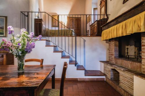 a dining room with a table and a staircase at Querceto Di Castellina in Castellina in Chianti