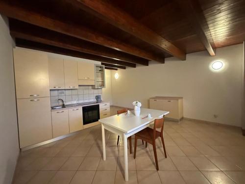 a kitchen with a white table and some chairs at Le due torri in Lecce neʼ Marsi