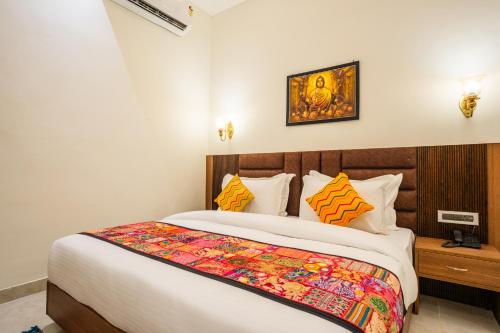 a bedroom with a large bed with a colorful blanket at Tripli Hotels Ganga Heaven Rishikesh - Laxman Jhula in Rishīkesh