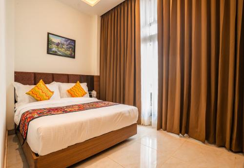a bedroom with a bed and a window with curtains at Tripli Hotels Ganga Heaven Rishikesh - Laxman Jhula in Rishīkesh