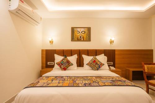 a hotel room with a bed with pillows at Tripli Hotels Ganga Heaven Rishikesh - Laxman Jhula in Rishīkesh