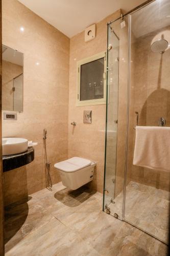 a bathroom with a shower and a toilet and a sink at Tripli Hotels Ganga Heaven Rishikesh - Laxman Jhula in Rishīkesh