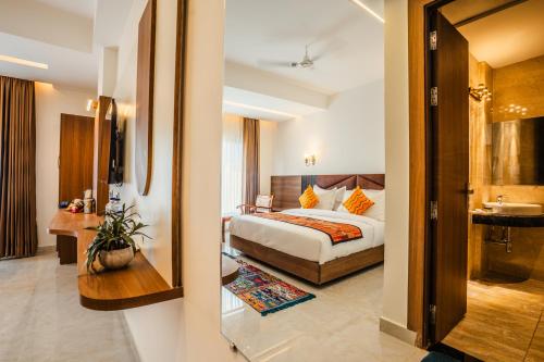 a hotel room with a bed and a bathroom at Tripli Hotels Ganga Heaven Rishikesh - Laxman Jhula in Rishīkesh