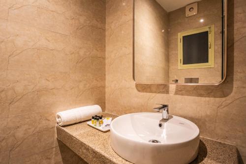 a bathroom with a sink and a mirror at Tripli Hotels Ganga Heaven Rishikesh - Laxman Jhula in Rishīkesh
