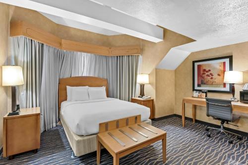 a bedroom with a bed and a desk and a computer at Radisson Hotel Salt Lake City Airport in Salt Lake City