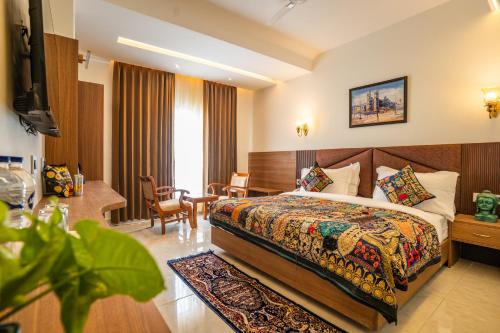 a hotel room with a bed and a desk at Tripli Hotels Ganga Heaven Rishikesh - Laxman Jhula in Rishīkesh