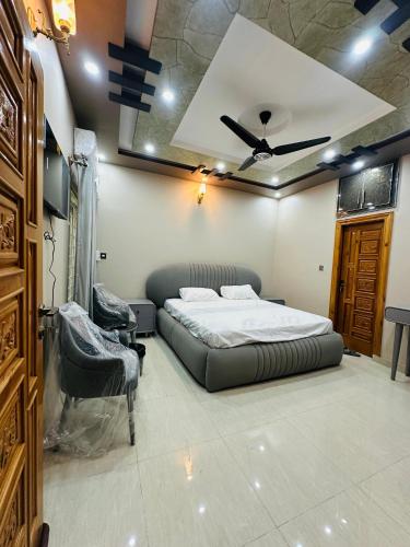a bedroom with a bed and a ceiling fan at Tabbis Guest House in Islamabad