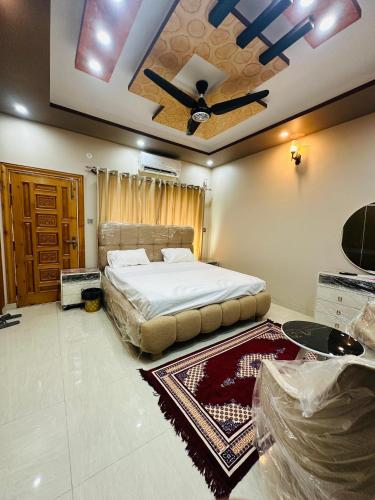a bedroom with a bed and a ceiling fan at Tabbis Guest House in Islamabad