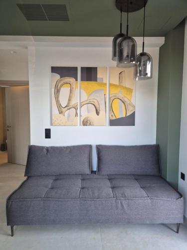 a couch in a living room with paintings on the wall at Allargo Project in Gerani