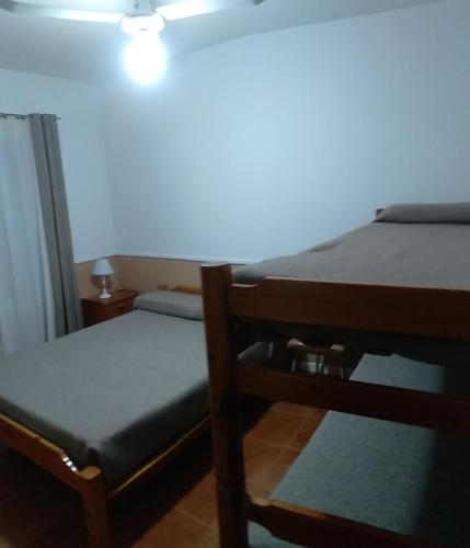 a bedroom with two bunk beds and a lamp at La Colonial Cabañas in Villa Cura Brochero