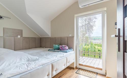 a bedroom with a bed and a large window at słoneczne zacisze dębina in Debina