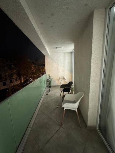 Un balcón con dos sillas y vista a una ciudad. en Apartament in Bucuresti, en Bucarest