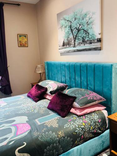 a bedroom with a blue bed with purple pillows at Super King, Close to Beach, Shops, Train, Shared Bathroom in St. Leonards