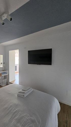 a bedroom with a bed with a flat screen tv on the wall at Sidera Cinque Terre Apartments in Biassa