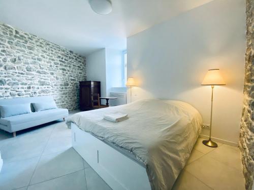 Un dormitorio con una cama y una pared de ladrillo. en Le Bastion, 15 guests, 5 suites, 5 baths, AC, en Pouzols-Minervois