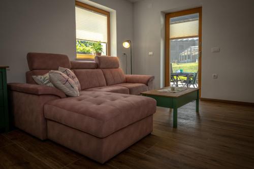 a living room with a couch and a table at Apartments Šlosarjeva Hiša Nature & Tradition in Preddvor