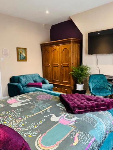 a living room with a bed and a couch at Super King, Close to Beach, Shops, Train, Shared Bathroom in St. Leonards