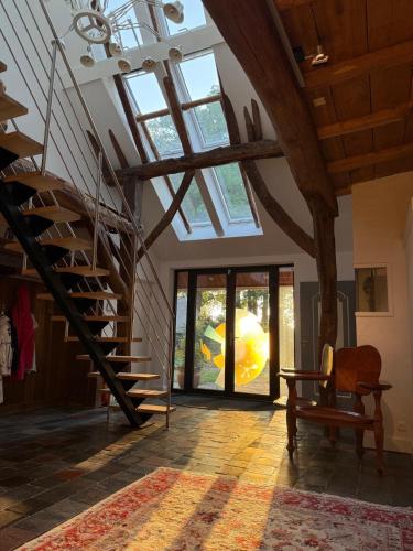 a living room with a staircase and a window at Landgoed Getafix in Balkbrug