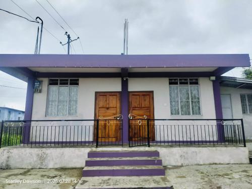 een klein huisje met twee houten deuren en een trap bij Ado Homestay in Shillong