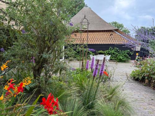 a garden with flowers in front of a building at Landgoed Getafix in Balkbrug