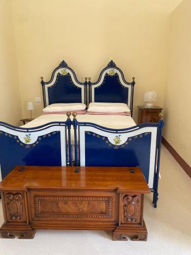 a bedroom with a blue bed with a wooden dresser at Vico Grazie in Campi Salentina