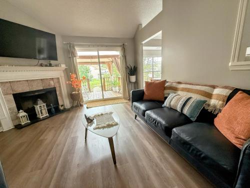 a living room with a black couch and a fireplace at Savannah Lakefront Retreat near Tybee Beach with King Bed and Free Parking in Savannah