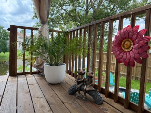 two figurines sitting on a deck next to a flower at Savannah Lakefront Retreat near Tybee Beach with King Bed and Free Parking in Savannah
