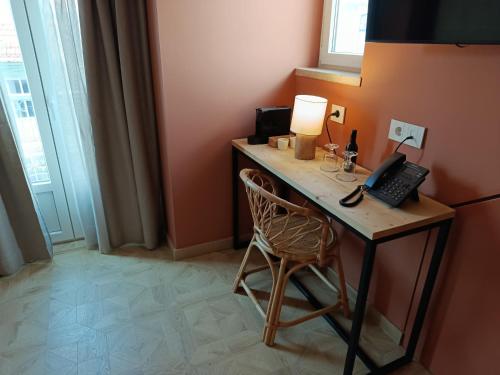 a desk with a telephone and a lamp on it at Dalma Baixa in Lisbon