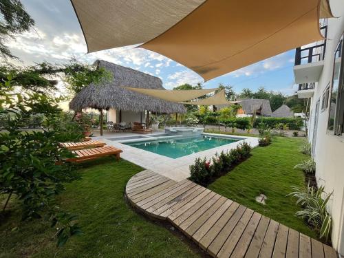 a backyard with a swimming pool and a house at Villa Almendro - 4 habitaciones in Iztapa
