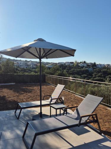 two lounge chairs and an umbrella on a patio at Allargo Project in Gerani
