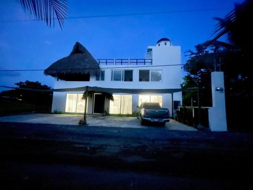 a white house with a car parked in front of it at Villa Almendro - 4 habitaciones in Iztapa