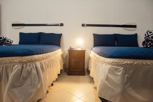 two beds with blue pillows in a room at Villa Almendro - 4 habitaciones in Iztapa