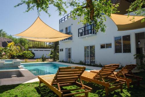 a house with a swimming pool with chairs and a house at Villa Almendro - 4 habitaciones in Iztapa
