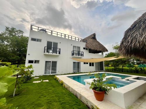 a villa with a swimming pool and a house at Villa Almendro - 4 habitaciones in Iztapa