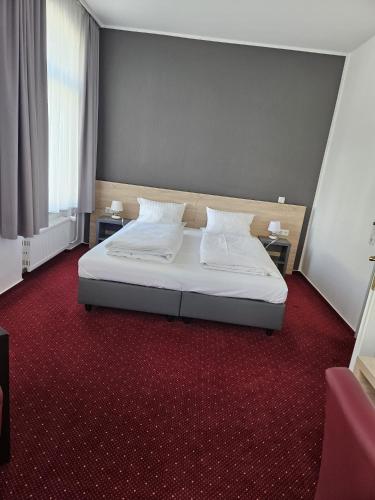 a bedroom with a bed with white sheets and pillows at Hotel Deutsches Haus in Blomberg